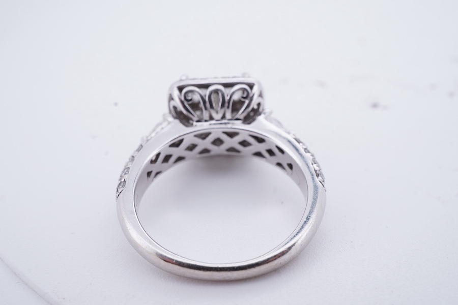 A diamond ring, centring on a tessellated arrangement of princess-cut and triangular diamonds totalling approximately 0.50 carats, to a border and band pavé-set with brilliant-cut diamonds, the shoulders accented with ad